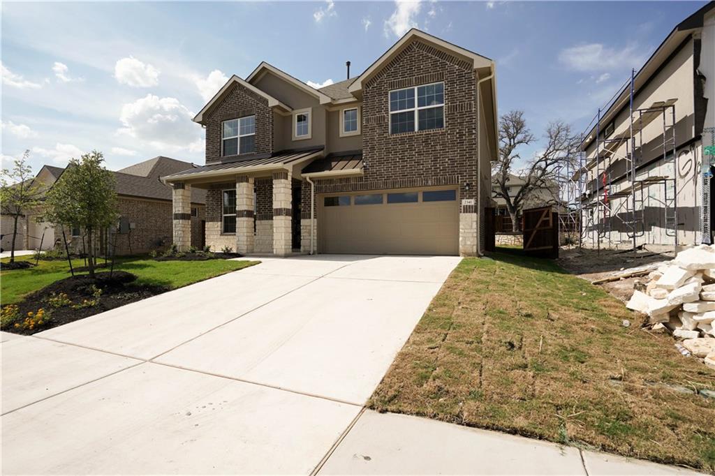 2341 Gabriels Horn Road Leander, TX 78641 - Photo 2 of 20 View of front facade with brick siding, concrete driveway, a standing seam roof, a garage, and a metal roof