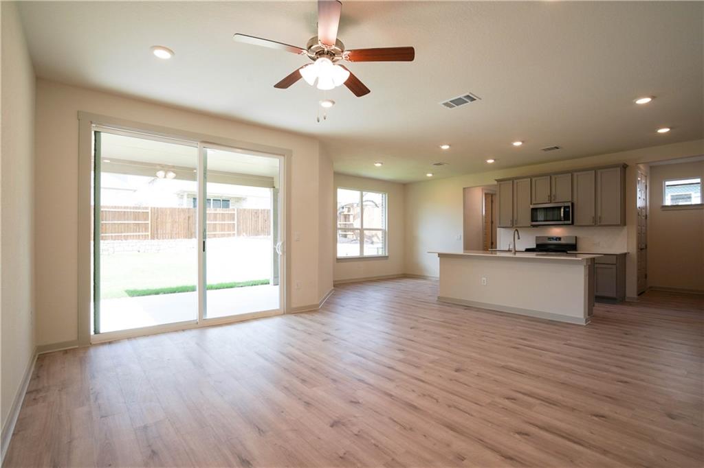 2341 Gabriels Horn Road Leander, TX 78641 - Photo 18 of 20 Kitchen featuring open floor plan, an island with sink, recessed lighting, gray cabinetry, and ceiling fan