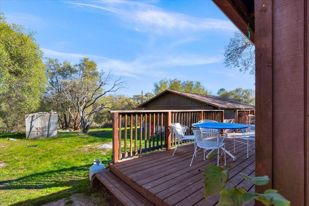 45522 Windmill Road Coarsegold, CA 93614 - Photo 54 of 74 a view of a deck with a table chairs and a yard