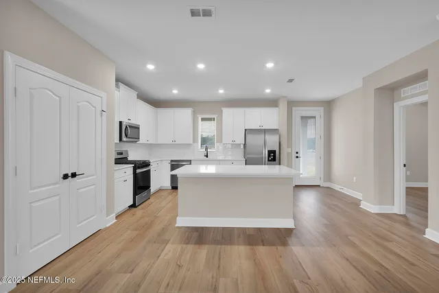 a view of kitchen with cabinets and refrigerator