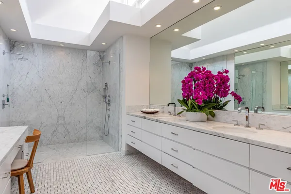 a bathroom with a granite countertop sink a mirror and a shower