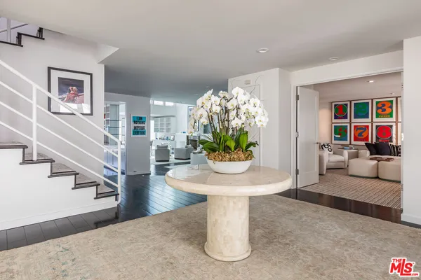 a living room with furniture flowerpot and a chandelier