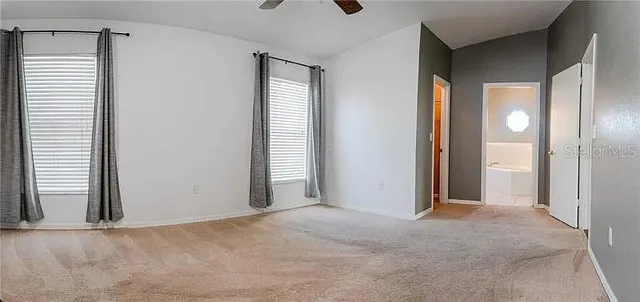 a view of a room with a ceiling fan and window