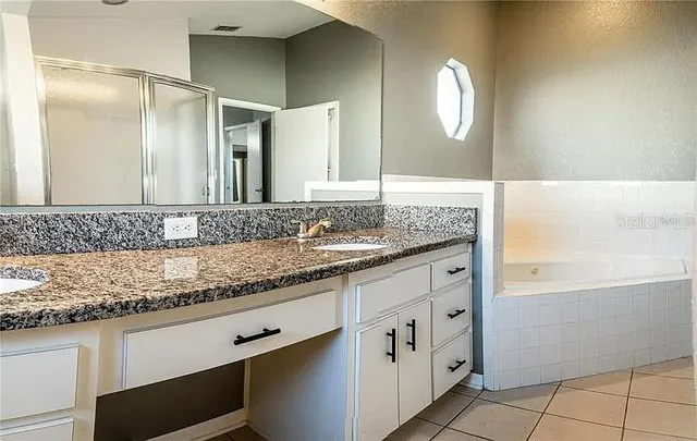 a bathroom with a granite countertop sink and a mirror