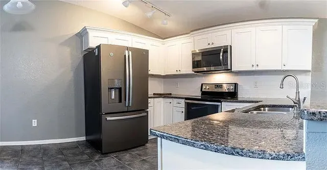 a kitchen with a refrigerator stove and sink