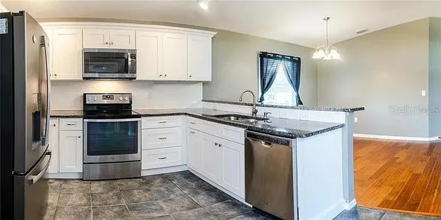 a kitchen with stainless steel appliances granite countertop a stove and a sink