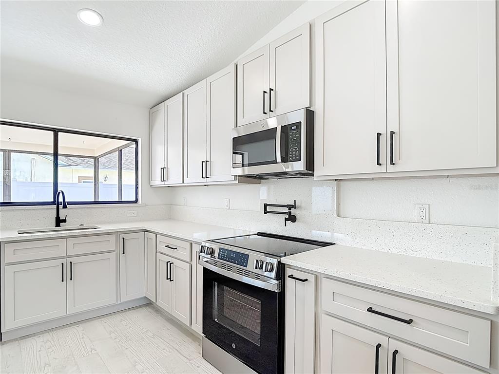 7478 Dundee Way Weeki Wachee, FL 34613 - Photo 17 of 52 a kitchen with white cabinets stainless steel appliances and sink