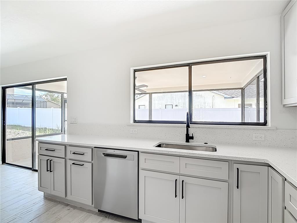 7478 Dundee Way Weeki Wachee, FL 34613 - Photo 20 of 52 a kitchen with stainless steel appliances a sink stove and cabinets