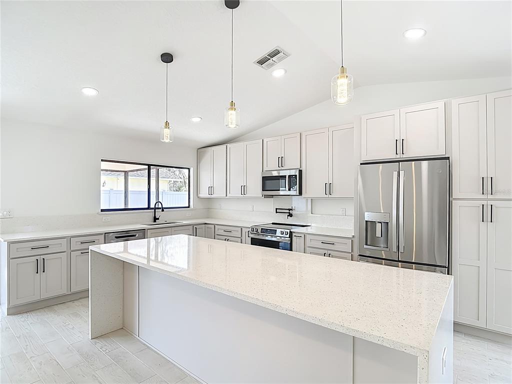 7478 Dundee Way Weeki Wachee, FL 34613 - Photo 23 of 52 a large kitchen with cabinets
