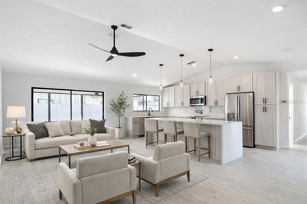 7478 Dundee Way Weeki Wachee, FL 34613 - Photo 25 of 52 a living room with furniture a ceiling fan a flat screen tv and windows