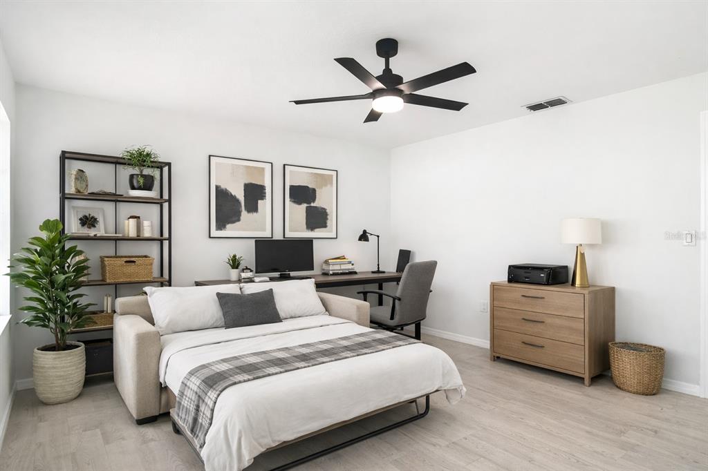 7478 Dundee Way Weeki Wachee, FL 34613 - Photo 27 of 52 a bedroom with a bed and wooden floor