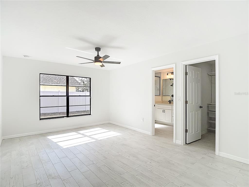 7478 Dundee Way Weeki Wachee, FL 34613 - Photo 29 of 52 an empty room with windows and ceiling fan view
