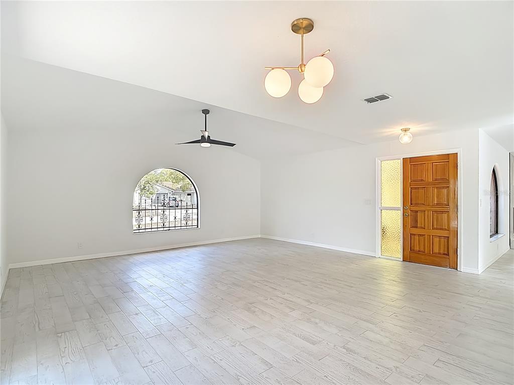 7478 Dundee Way Weeki Wachee, FL 34613 - Photo 10 of 52 an empty room with wooden floor and windows