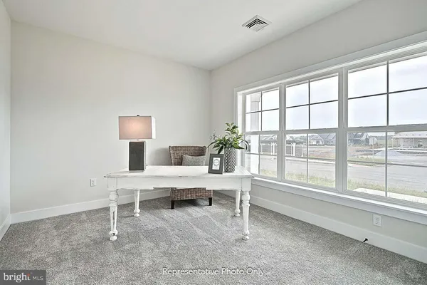 a view of a workspace with furniture and a window