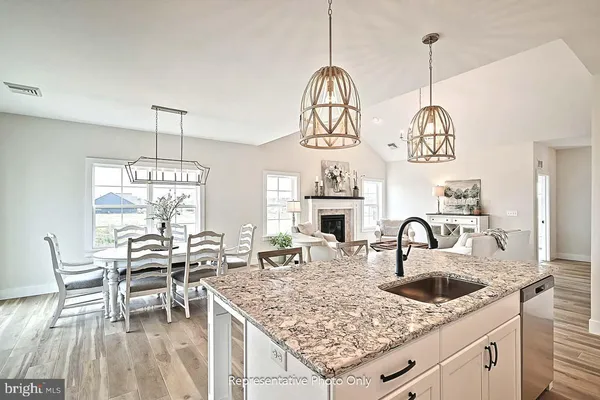 a kitchen with stainless steel appliances granite countertop a stove a kitchen island a dining table and chairs with wooden floor