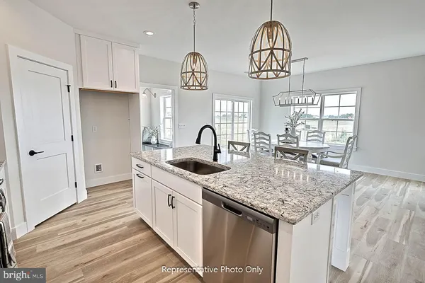 a kitchen with stainless steel appliances granite countertop a sink dishwasher and a stove with wooden floor