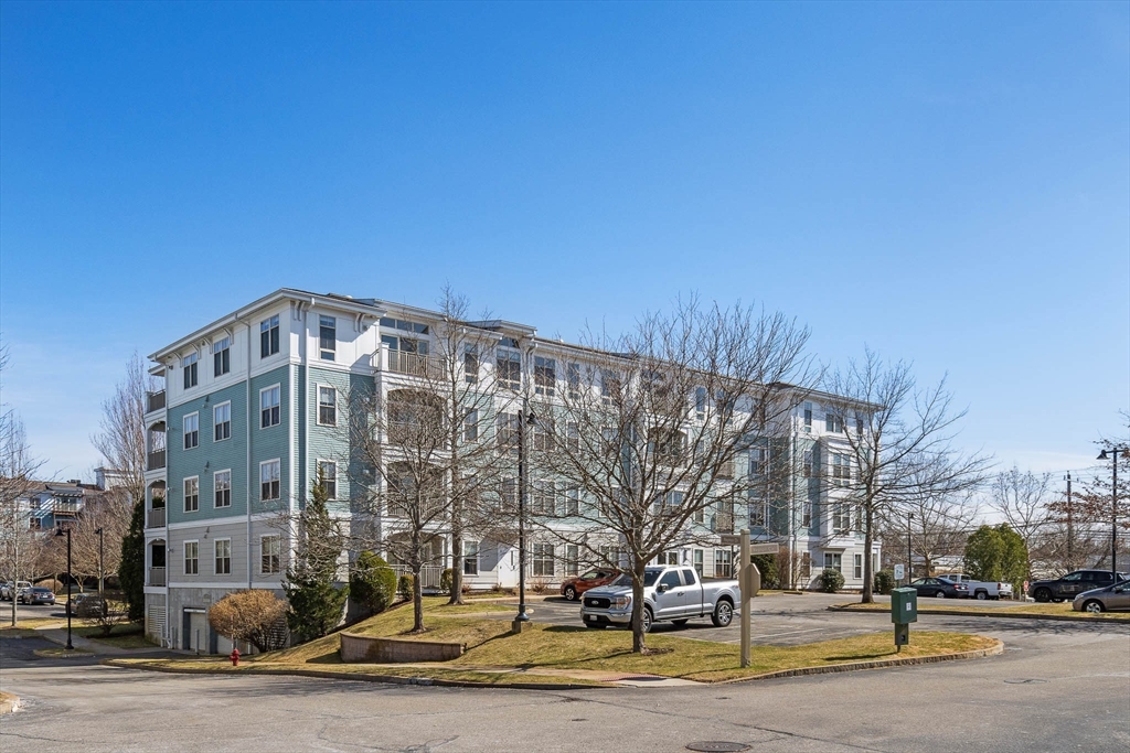 4 Repton Place, Unit 4213 Watertown, MA 02472 - Photo 1 of 19 a view of a building with lot of cars and trees