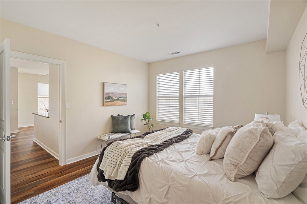 4 Repton Place, Unit 4213 Watertown, MA 02472 - Photo 11 of 19 a bedroom with a bed and wooden floor
