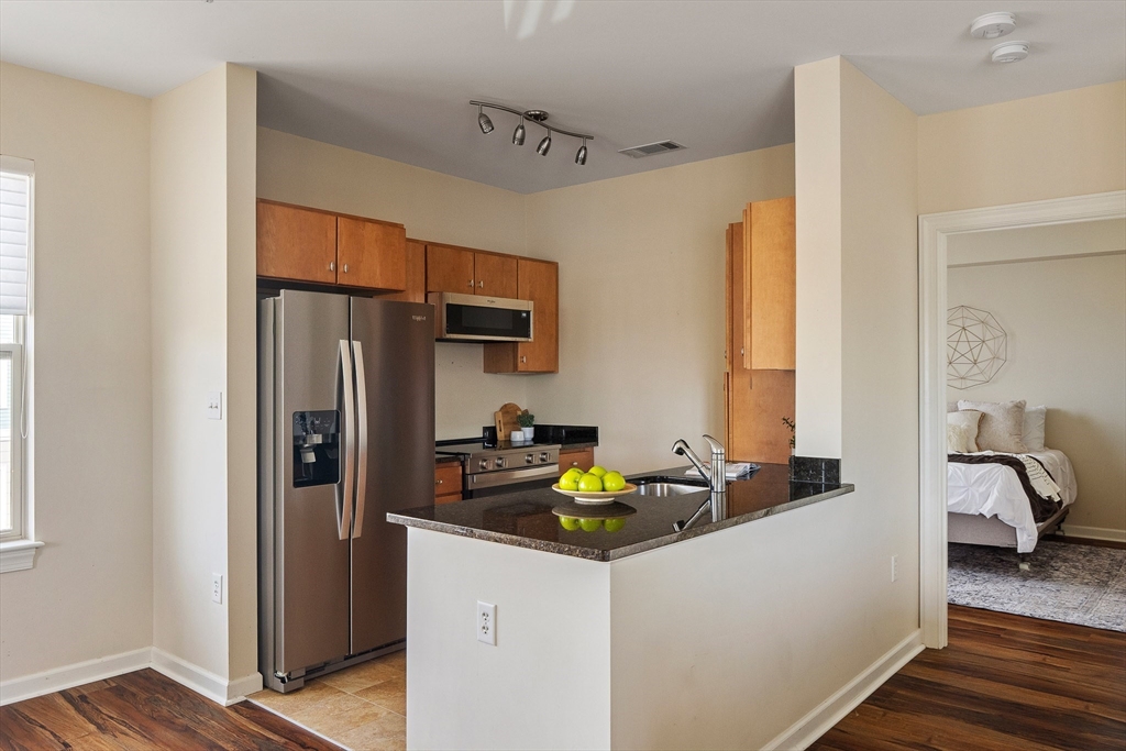 4 Repton Place, Unit 4213 Watertown, MA 02472 - Photo 10 of 19 a kitchen with stainless steel appliances granite countertop a refrigerator and a sink