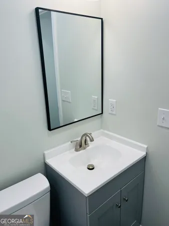 a bathroom with a sink a toilet and mirror