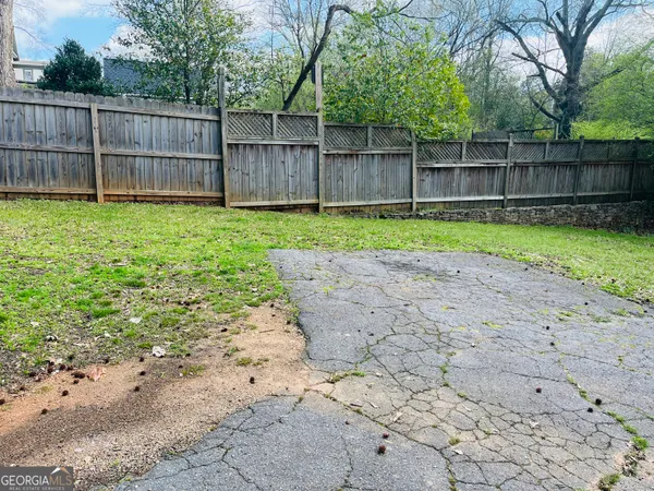 a view of a yard with a small yard and wooden fence