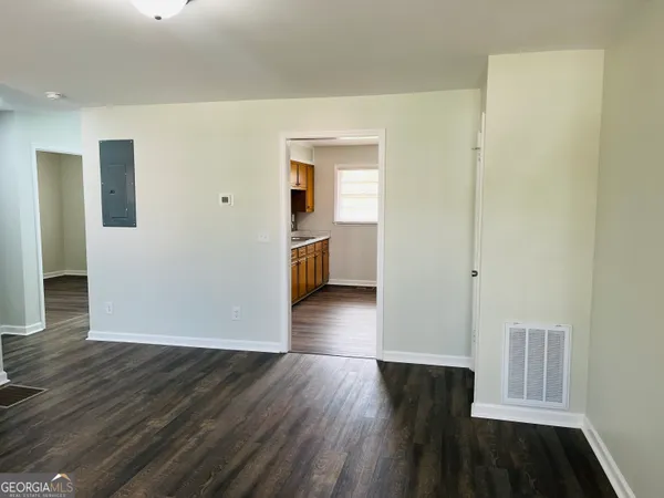 a view of a hallway with wooden floor and closet