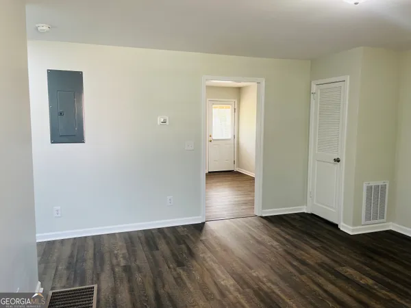 an empty room with wooden floor and closet