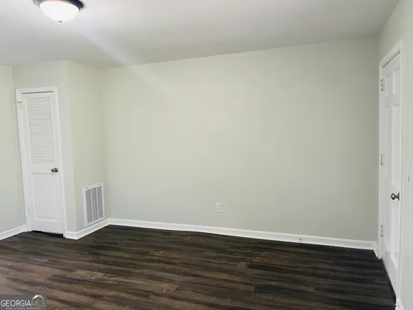 a view of an empty room with wooden floor