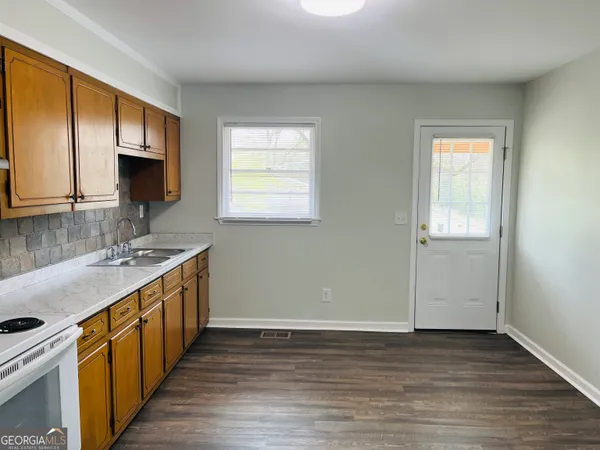 a kitchen with stainless steel appliances granite countertop a sink stove and cabinets