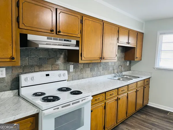 a kitchen with stainless steel appliances a stove a sink and a microwave