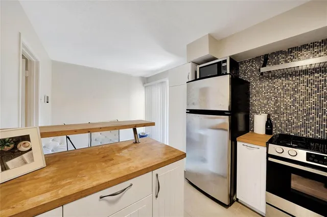 a kitchen with stainless steel appliances granite countertop a refrigerator and a stove