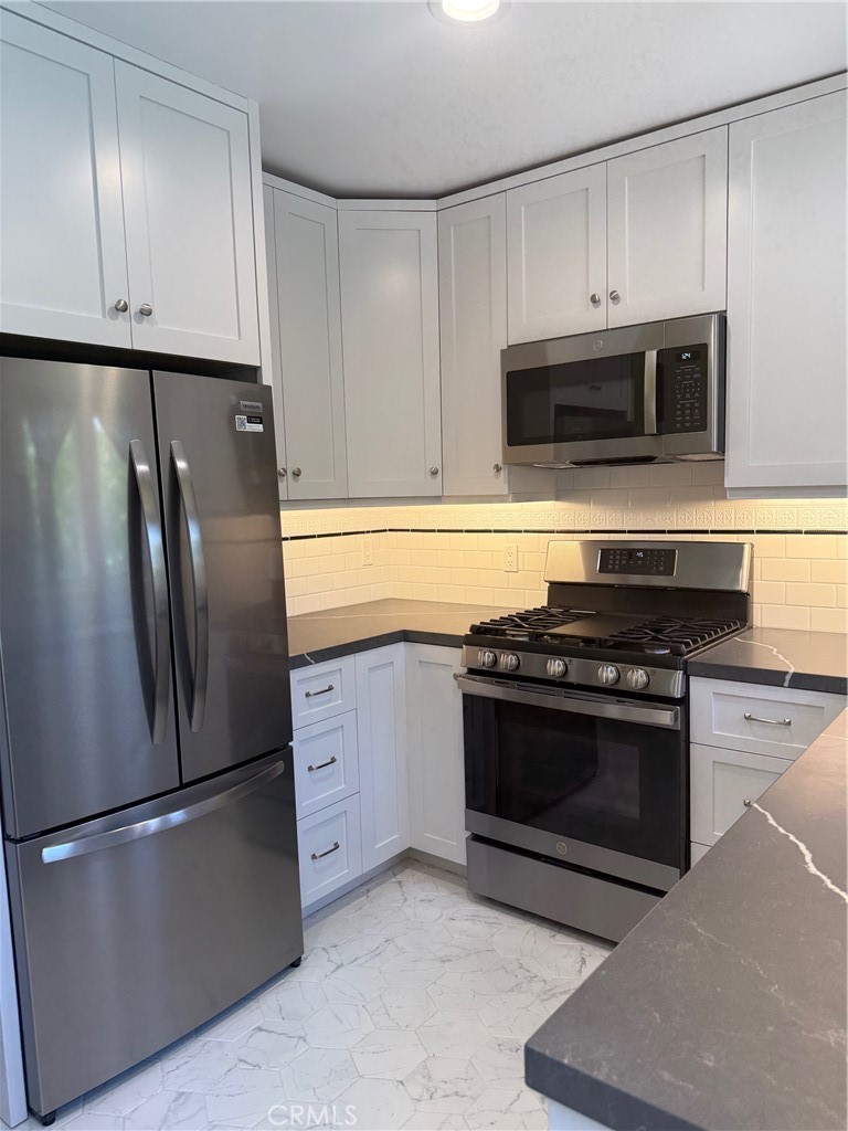 297 Garfield Avenue Pasadena, CA 91101 - Photo 11 of 28 a kitchen with stainless steel appliances granite countertop a refrigerator stove and microwave