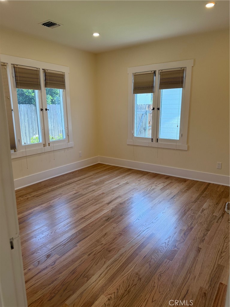 297 Garfield Avenue Pasadena, CA 91101 - Photo 15 of 28 an empty room with wooden floor and windows