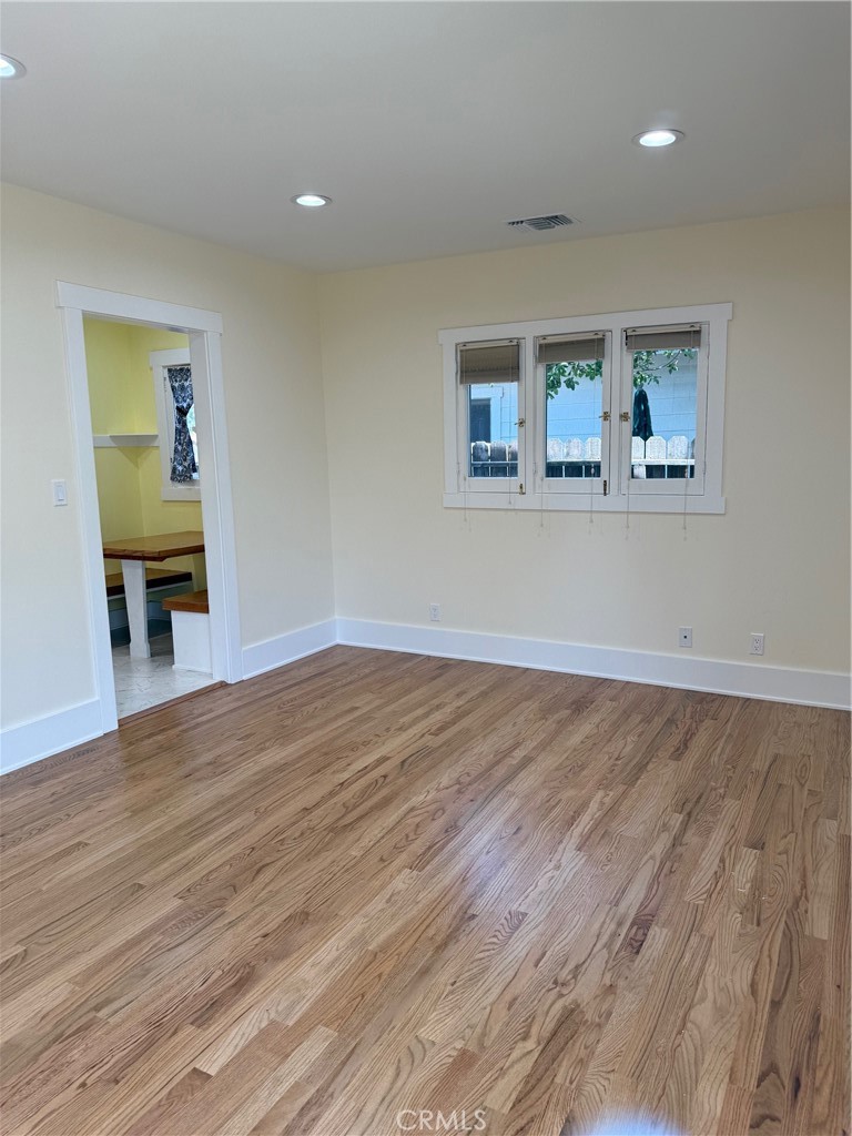 297 Garfield Avenue Pasadena, CA 91101 - Photo 6 of 28 an empty room with wooden floor and painting on the wall