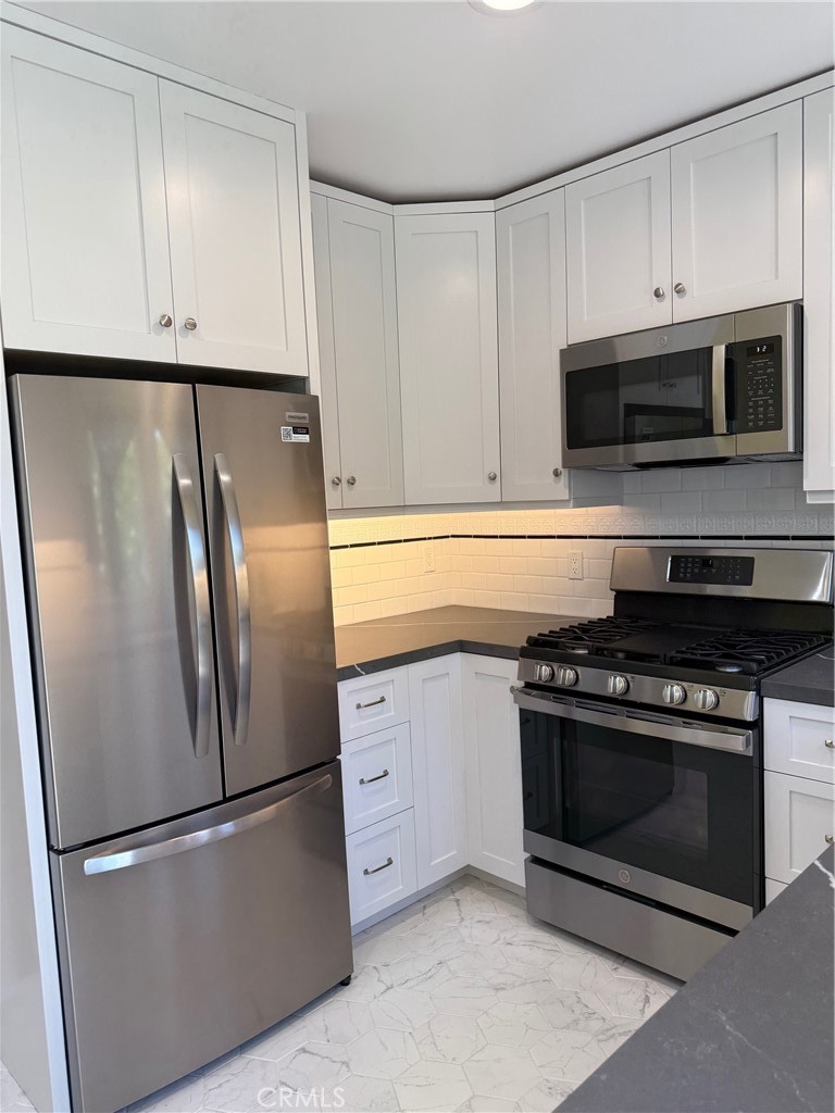 297 Garfield Avenue Pasadena, CA 91101 - Photo 8 of 28 a kitchen with stainless steel appliances granite countertop a stove a refrigerator and a microwave