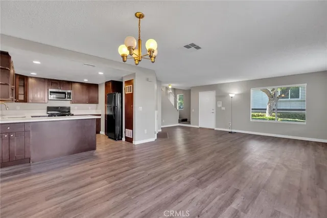 a view of a kitchen with a sink a refrigerator and a fireplace