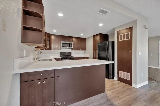 a kitchen with stainless steel appliances a refrigerator sink and microwave