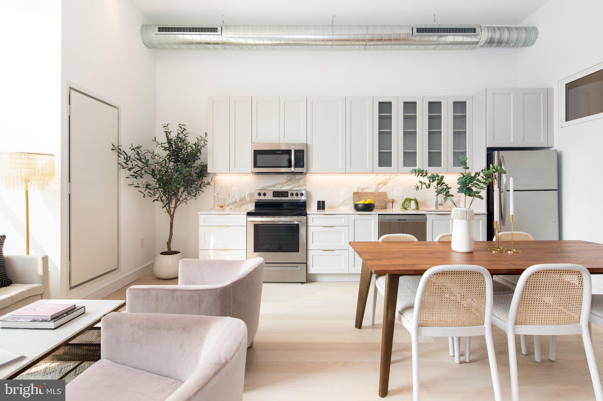 a dining room with furniture and a kitchen view