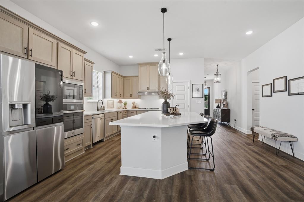 1632 Cotton Road Van Alstyne, TX 75495 - Photo 8 of 40 a kitchen with stainless steel appliances a refrigerator a sink dishwasher a stove and white cabinets with wooden floor