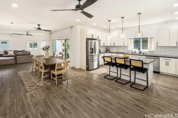 a dining room with stainless steel appliances wooden floors stove and kitchen view