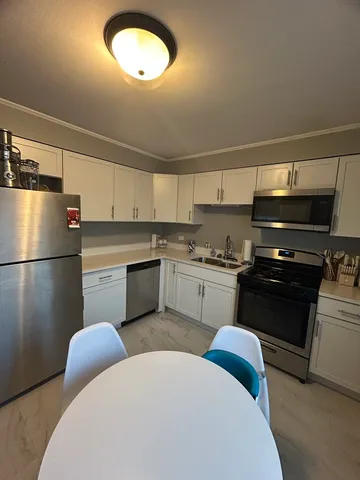 a kitchen with stainless steel appliances a refrigerator sink and cabinets