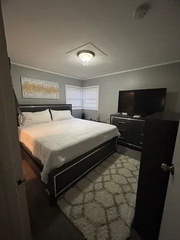 a bedroom with a bed and a flat screen tv