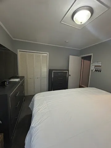 a bedroom with a bed and a flat screen tv