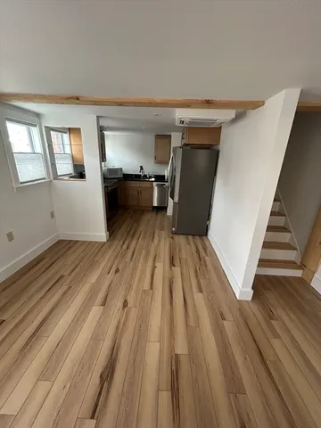 a view of a living room with wooden floor and staircase
