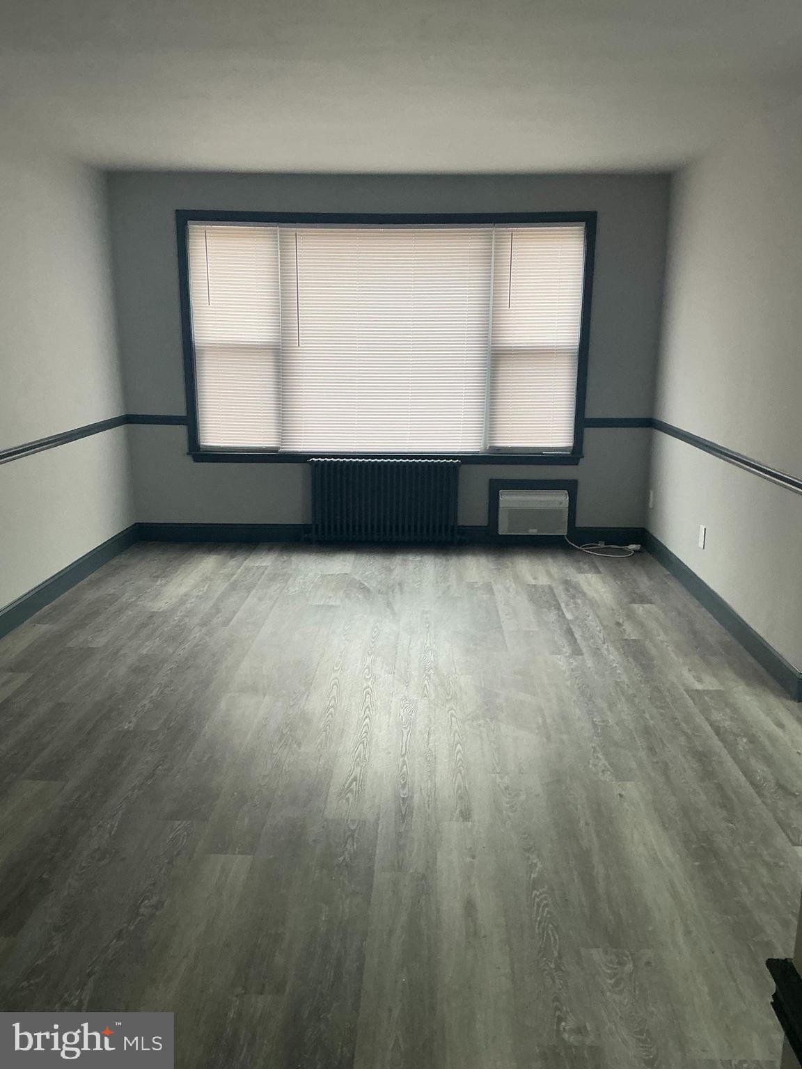 4004 E Street Southeast, Unit 106 Washington, DC 20019 - Photo 14 of 17 an empty room with wooden floor and windows