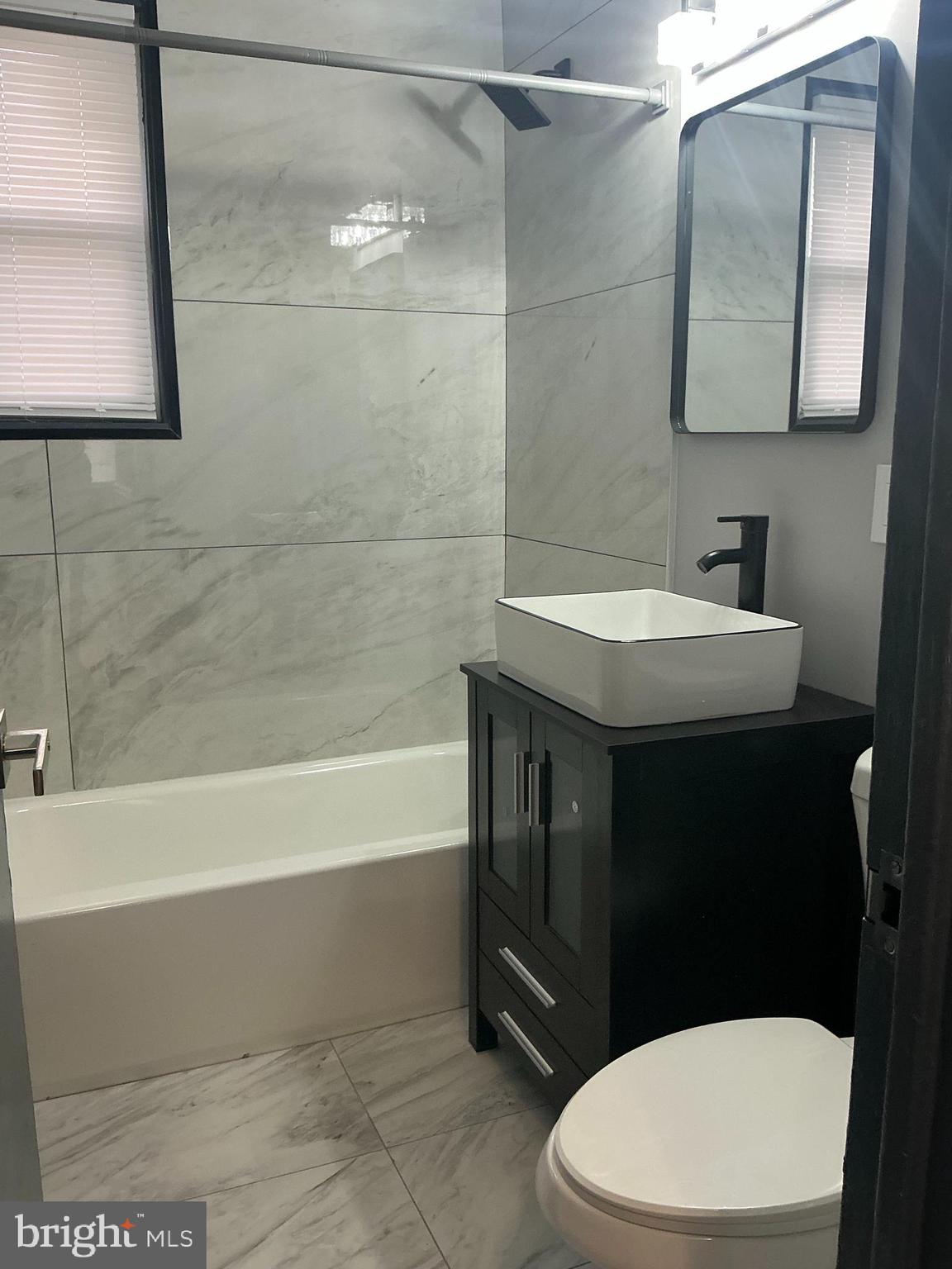 4004 E Street Southeast, Unit 106 Washington, DC 20019 - Photo 17 of 17 a bathroom with a sink a toilet and bathtub