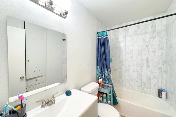 a bathroom with a sink vanity mirror and toilet