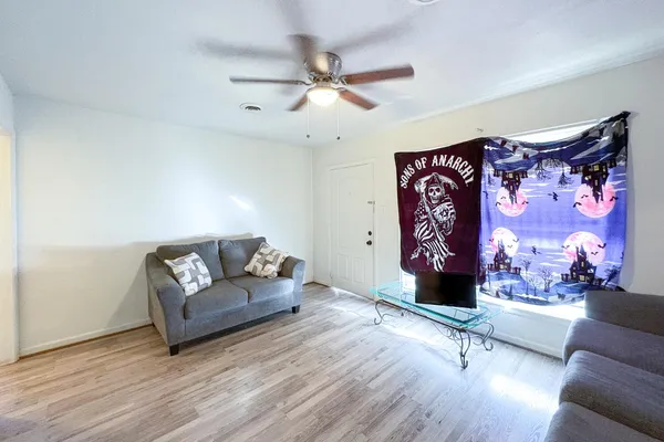 a living room with furniture and a wooden floor