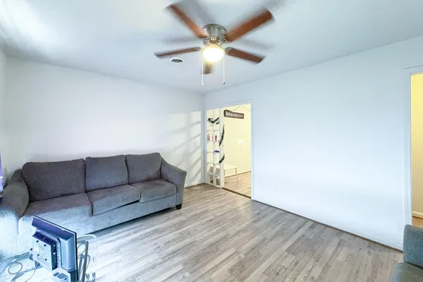a living room with furniture and a ceiling fan