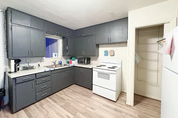 a kitchen with a stove sink and cabinets